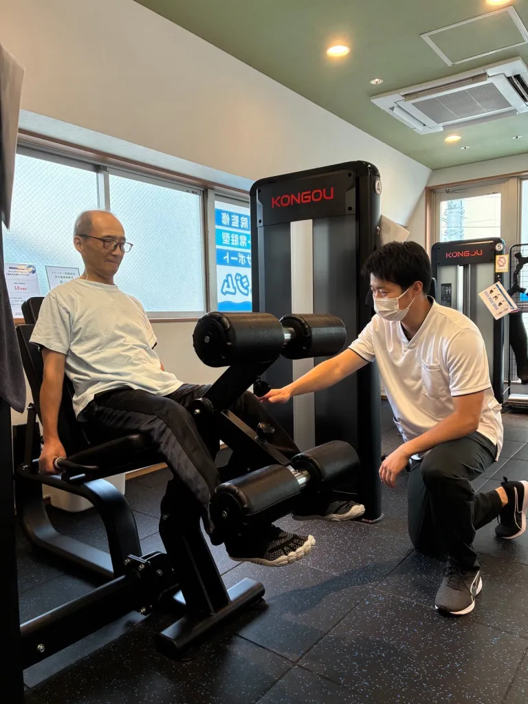 会員がマシンで運動し、高木トレーナーが動きを確認する様子