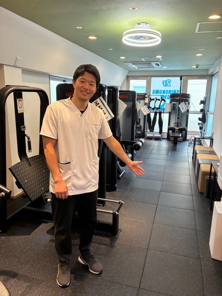 理学療法士の高木がジム内を案内する様子